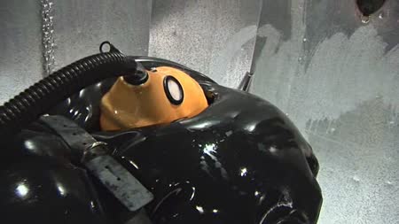 Heavy Rubber Torment Part 3 - Still encased in tight black heavy rubber, a tube is connected to her thick rubber hood, all the while the electric pussy plug is pulsing through her making her climax again and again in her rubber tomb.